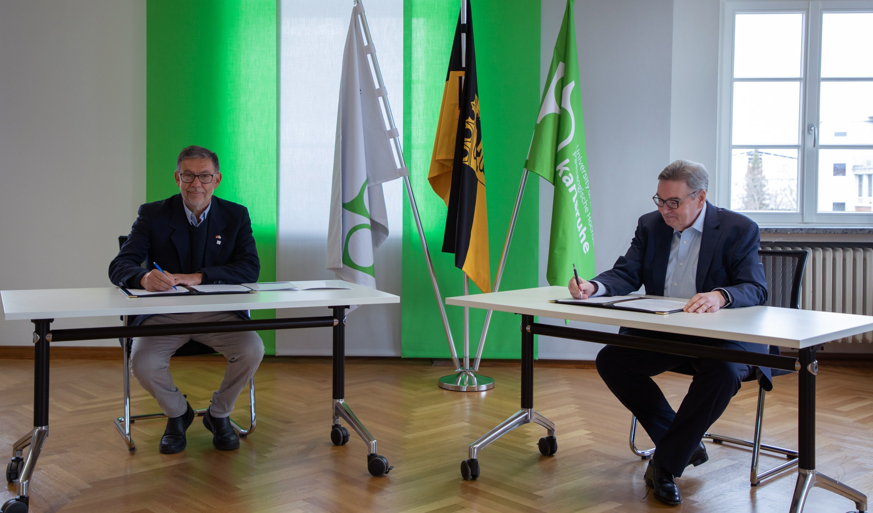 Zusammenarbeit mit argentinischer Universidad Nacional de Rafaela: Die beiden Rektoren, Prof. Dr. Rubén A. Ascúa (l.) und Prof. Dr. Klaus Peter Rippe (PHKA), unterzeichnen den Kooperationsvertrag. Foto: Lea Schmitt/Pädagogische Hochschule Karlsruhe