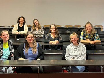 Eine kleine Gruppe Studierender sitzt ein einem Hörsaal.