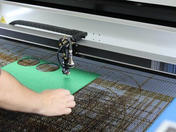 Eine Person bedient einen Lasercutter.