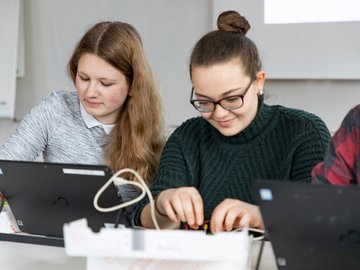 Zwei Schülerinnen der Sekundarstufe I experimentieren am Laptop