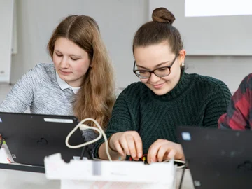 Zwei Schülerinnen der Sekundarstufe I experimentieren am Laptop