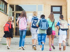 Schulkinder betreten Schulhaus