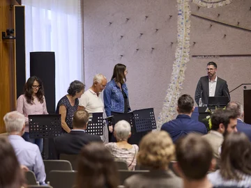 Vier Personen an Notenständern, auf denen iPads platziert sind - lauschen den Anweisungen von Prof. Kai Koch zum Musizieren.