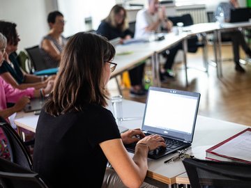 Mitglieder des Hochschulrats sitzen an einem Besprechungstisch