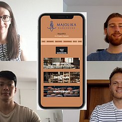 Der Screenshot zeigt vier Studierende in je einem eigenen Bildschirm, in der Mitte ist ein Smartphone eingebaut, das die Startseite des Projekts zur Majolika zeigt