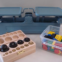 Bild mit Tafelwaage und unterschiedlichen Gewichten.